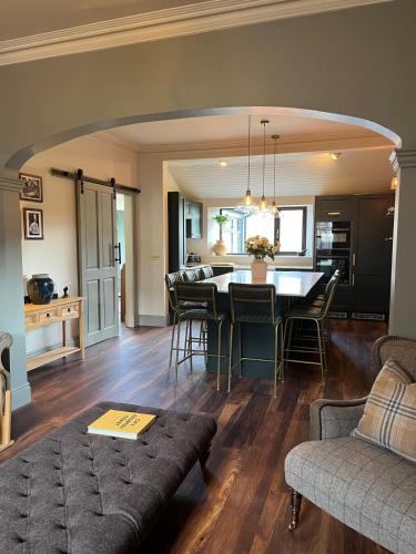 a living room and kitchen with a table and chairs at Lewis Lodge - Stunning & Exclusive Luxury Home in the Heart of Ballater, Royal Deeside in Ballater