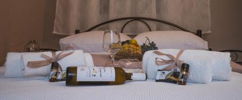 a bed with two bottles of wine and a basket of fruit at Roots House Pozar in Piperiaí