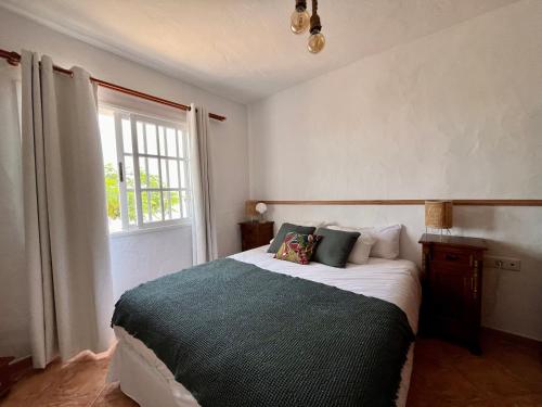 a bedroom with a large bed with a window at Casa Drago in Valles de Ortega