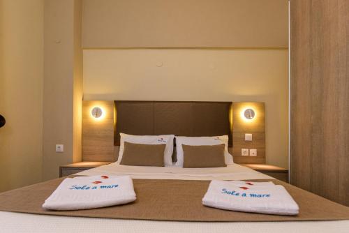 a bedroom with a large bed with two towels on it at Sole A Mare in Neos Marmaras