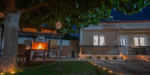 a building with a tree in front of it at Roots House Pozar in Piperiaí