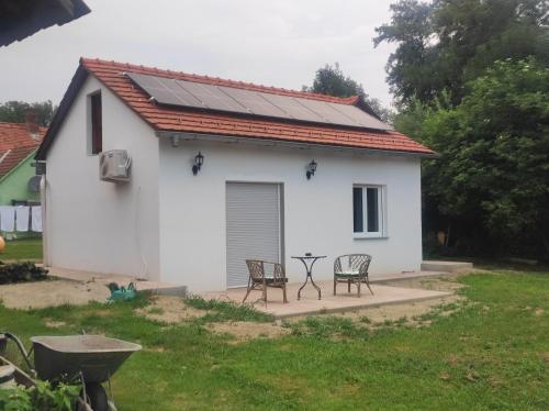 a white house with a solar roof and two chairs at Haus Yuphin in Hart bei Graz