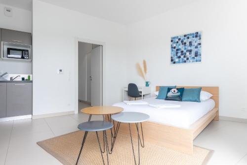 - une chambre avec un lit, 2 tables et 2 chaises dans l'établissement L'ensoleillé Superbe studio avec garage, à Caen