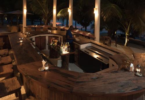 a man standing at a bar in a restaurant at Swahili Beach in Diani Beach