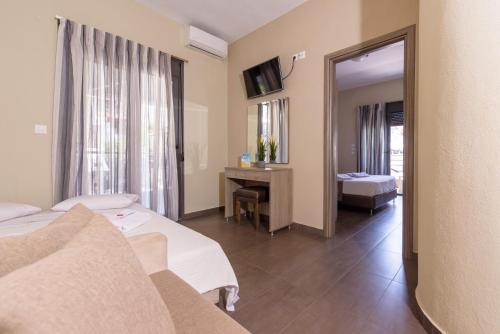 a hotel room with two beds and a mirror at Sole A Mare in Neos Marmaras