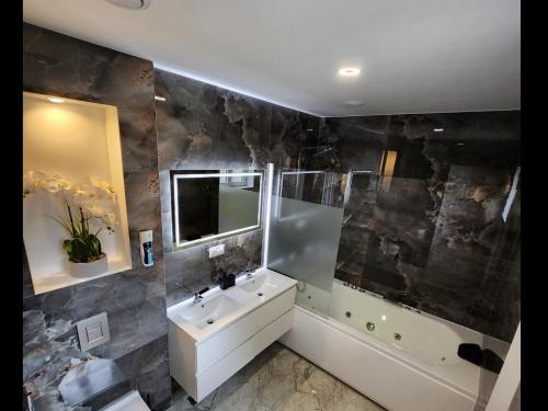 une salle de bain avec un lavabo, une baignoire et un miroir dans l'établissement Dima's Maison, à Sainte-Marie-aux-Mines