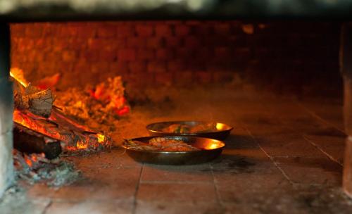 two metal pans sitting in a fire oven at Swahili Beach in Diani Beach