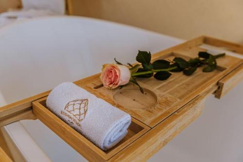 a wooden tray with a towel and a rose on a bed at Kosmaj Zomes in Rovače