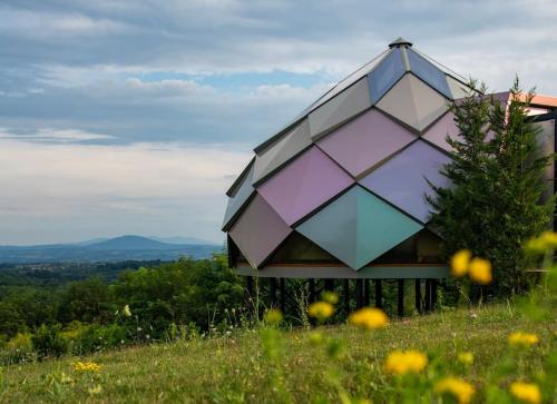 a building sitting on top of a grassy hill at Kosmaj Zomes in Rovače