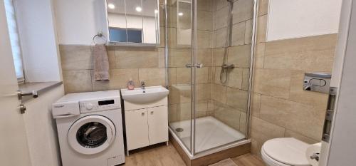 a bathroom with a washing machine and a shower at Haus am Nymphensee2 in Brieselang