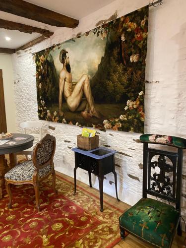 a painting of a woman sitting on a wall at Une nuit chez une artisane in Josselin