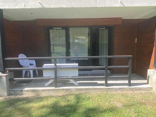 un banc sur la terrasse couverte d'une maison dans l'établissement Studio plein pied - Terrasse, à Saint-Jean-dʼAulps