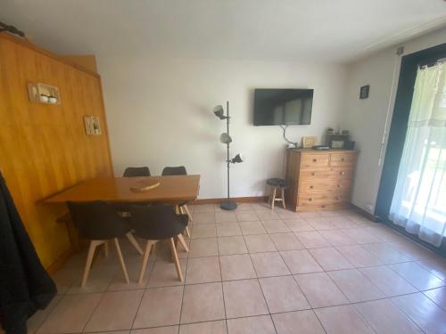 une salle à manger avec une table, des chaises et une télévision dans l'établissement Studio plein pied - Terrasse, à Saint-Jean-dʼAulps