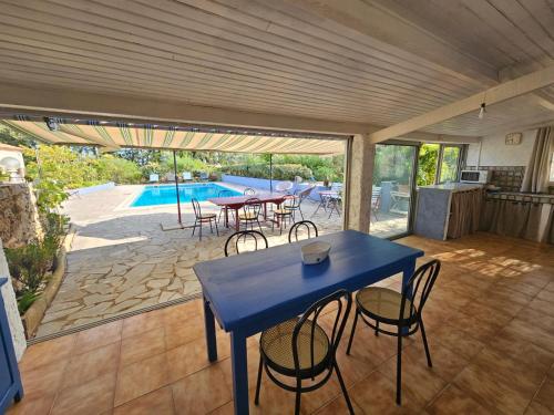 a blue table and chairs on a patio with a pool at La Genestière in Draguignan