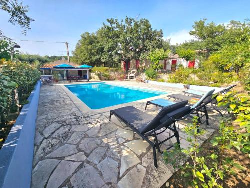 a swimming pool with a table and chairs next to it at La Genestière in Draguignan