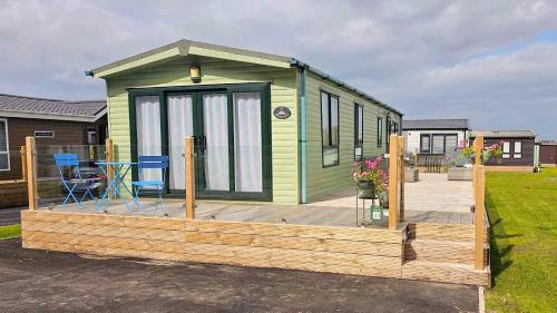 a green tiny house on a wooden deck at Foxgloves and Ivy in Cockermouth