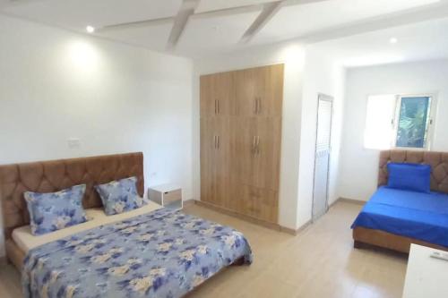 a bedroom with a large bed with blue pillows at Villa avec piscine in Korba