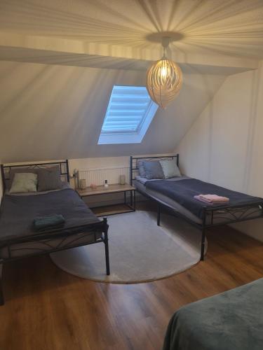 a attic room with two beds and a window at Haus Svetlana Zweizimmer Ferienwohnung in Berthelsdorf
