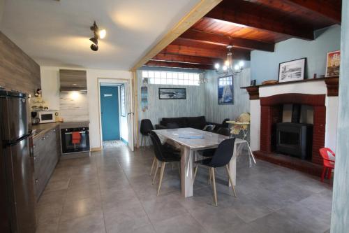 une cuisine et un salon avec une table et des chaises dans l'établissement Location Bord De Mer, à Bretteville-sur-Ay