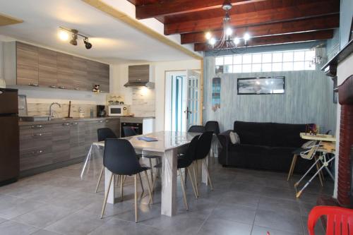 une cuisine et un salon avec une table et des chaises dans l'établissement Location Bord De Mer, à Bretteville-sur-Ay