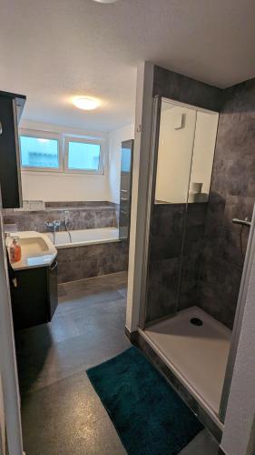 a bathroom with a shower and a sink and a tub at Ferienwohnung New York in Hohenstein-Ernstthal