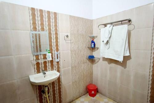 un baño con lavabo y espejo en Kanha Homestay, en Ayodhya