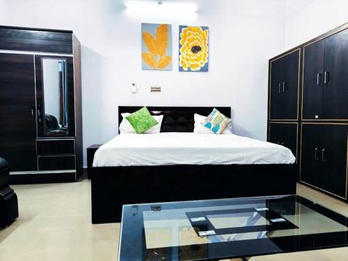 Un dormitorio con una cama y una mesa de cristal. en Kanha Homestay, en Ayodhya