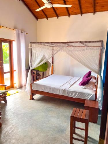 a bedroom with a bed with a canopy at Heaven Hill Guesthouse in Weligama