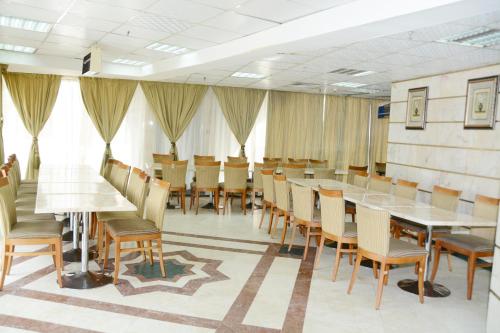a conference room with tables and chairs and curtains at Wahet Al Deafah Hotel in Mecca