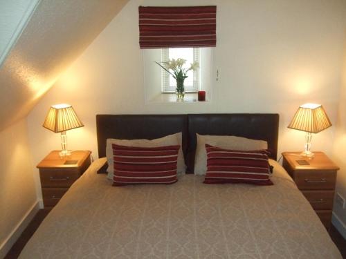 a bedroom with a large bed with two lamps at Links Lodge in Lossiemouth