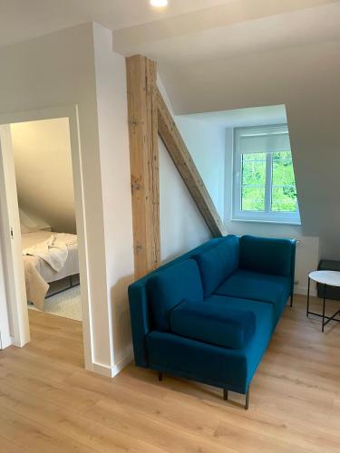 a living room with a blue couch and a bed at Szmaragdowa Sowa in Wałbrzych