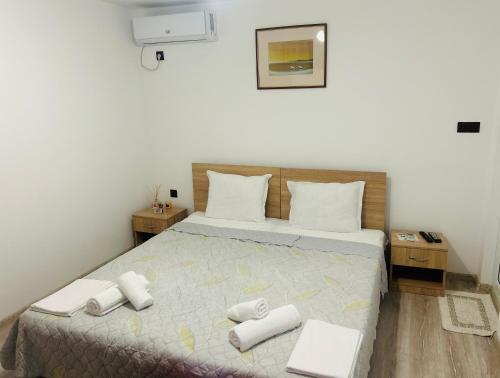 a bedroom with a bed with white towels on it at Вила ЕВА in Sinemorets