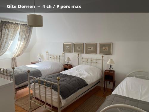 two twin beds in a bedroom with white walls at Les Gîtes du Manoir de Keryvon in Saint-Derrien