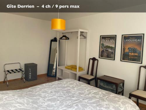 a bedroom with a bed and two chairs and a mirror at Les Gîtes du Manoir de Keryvon in Saint-Derrien
