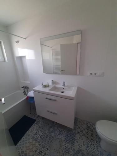 un bagno con lavandino, WC e specchio di Alojamiento tresdiva a El Astillero