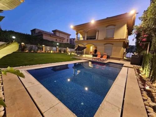a swimming pool in front of a house at villa Yasser Ezzat in Cairo