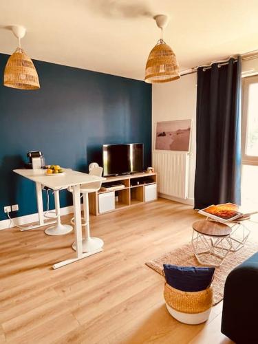 un salon avec une table blanche et un mur bleu dans l'établissement Le Dalgabio -1 min de la gare-, à Saint-Étienne
