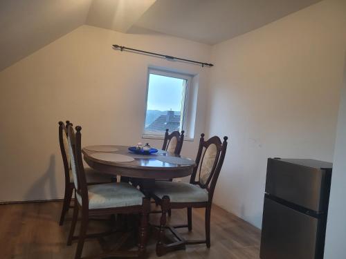 a dining room with a table and chairs and a window at Haus Svetlana Zweizimmer Ferienwohnung in Berthelsdorf