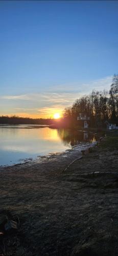 a sunset over a body of water with the sun setting at Haus am Nymphensee 4 in Brieselang