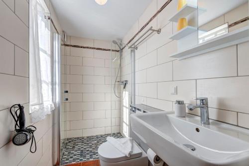 ein weißes Badezimmer mit Waschbecken und Toilette in der Unterkunft Gartenhaus am Schwanenteich in Lassan