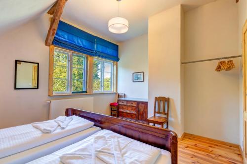 ein Schlafzimmer mit Bett, Schreibtisch und Fenster in der Unterkunft Gartenhaus am Schwanenteich in Lassan