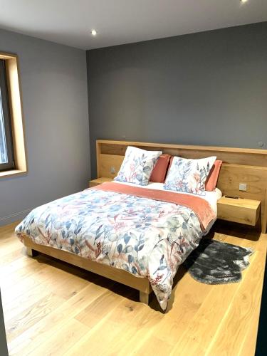 une chambre avec un lit avec une tête de lit en bois dans l'établissement Le Chai de Castres Gironde, à Castres-Gironde