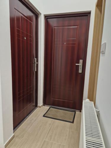 two wooden doors in a room with a wooden floor at Apartment Luxury B in Slavonski Brod