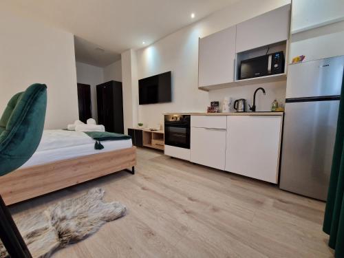 a kitchen with a bed and a refrigerator at Apartment Luxury B in Slavonski Brod