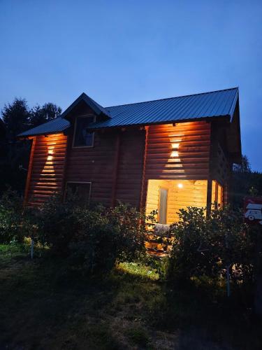 a log cabin at night with the lights on at Konaci Očeva Zemlja Vikendica i Bungalovi in Mojkovac