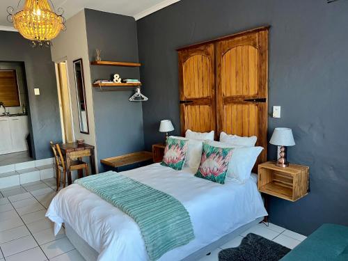 a bedroom with a large bed with a wooden headboard at Green Hollow Self catering in Knysna