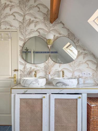 une salle de bain avec un miroir et un lavabo dans l'établissement Villa du Menhir, vue panoramique sur la mer - WarmHouse, à Plozévet