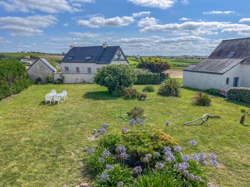 a garden with a house and some flowers at Villa du Menhir, vue panoramique sur la mer - WarmHouse in Plozévet