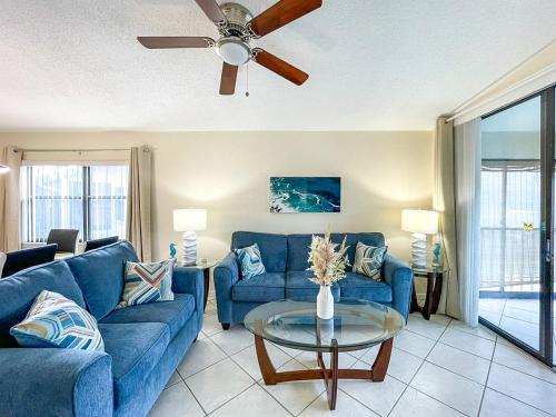 a living room with blue couches and a ceiling fan at Spacious Shorewalk 2B-2B Condo near Anna Maria Island, Beaches & IMG Academy in Bradenton