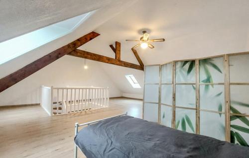 une chambre avec un lit et un ventilateur de plafond dans l'établissement Grand gîte chez Gina, à Grand-Fort-Philippe